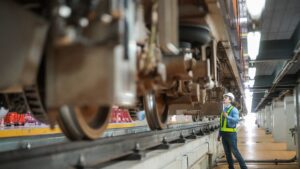 Engineer inspects tracks and train components.