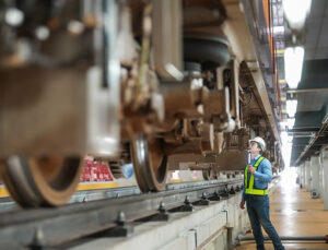 Engineer inspects tracks and train components.