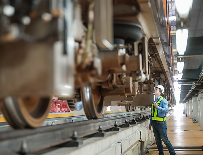 Engineer inspects tracks and train components.