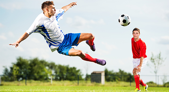 Fußballspieler beim Schuss mit Ball in der Luft – Beispiel für Ballflugbahnanalyse mit Hochgeschwindigkeitskamera