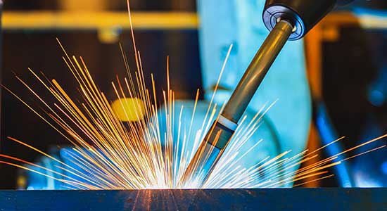 Schweißprozess mit Funkenflug bei der automatisierten Schweißnahtkontrolle in der industriellen Fertigung